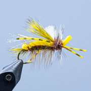 Tied foam fly on hook with yellow foam wings and white feather fibers