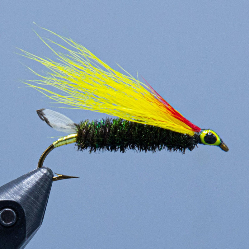 Fishing lure with dark green fuzzy body, yellow/red wing, and black hook
