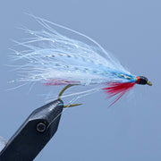 Multicolor streamer fly with white tail, blue iridescence, and barbed hook