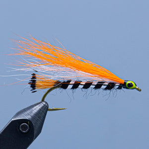A black orange and white bucktail streamer fishing fly