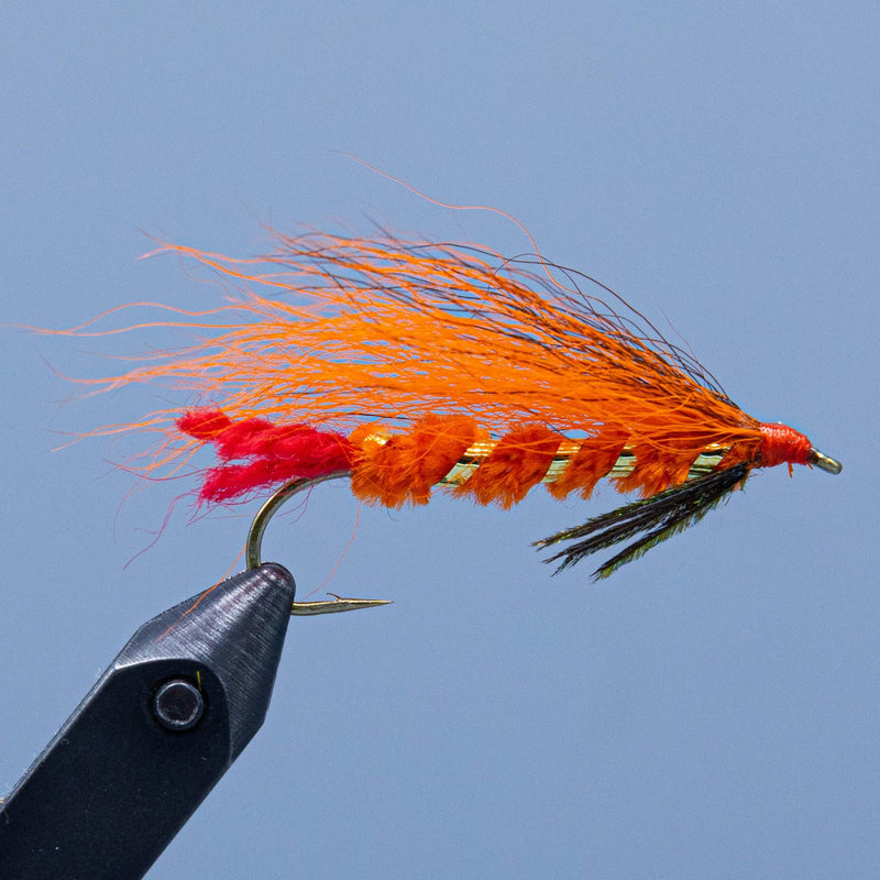 Feather fishing lure with orange-red streamer, multicolor tail, on black hook