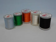 Assorted silk floss spools in black, green, orange, light gray and white