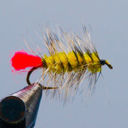 Feather fishing fly lure with yellow-green fuzzy body, red tail, curved black hook