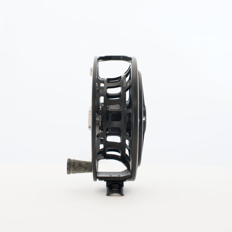 Fishing reel, matte black side view with arched cutouts and dark knob grip