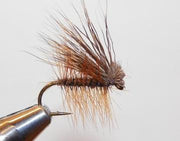 Deer hair caddis fly with brown hair wing and dark body, curved hook