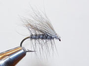 Deer hair caddis fly with gray hair wing and dark tying, curved hook