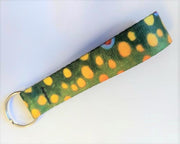 Wingo key fob with green patterned fabric strap and metal keyring, close-up
