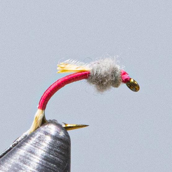 WD-50 fly fishing lure with red thread body, gray dubbing head, and yellow tail fibers
