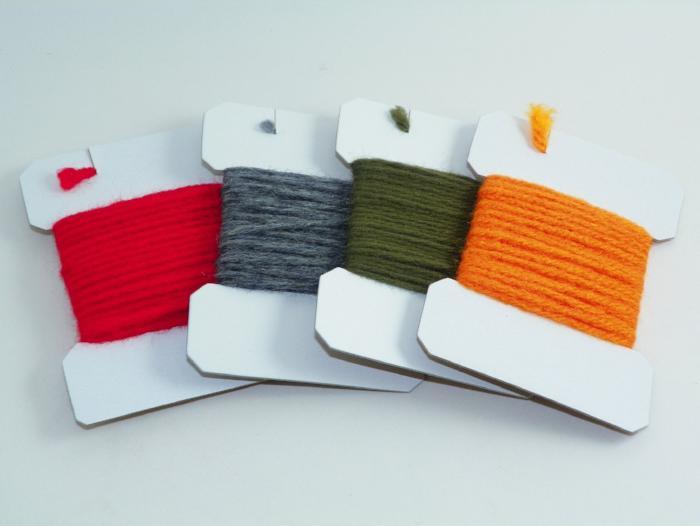 Wool yarn set on cardboard cards: red, gray, olive green, and orange spools.